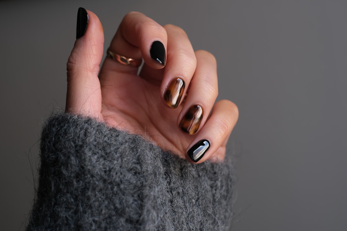 Close-up of a hand with dark manicure and silver ring