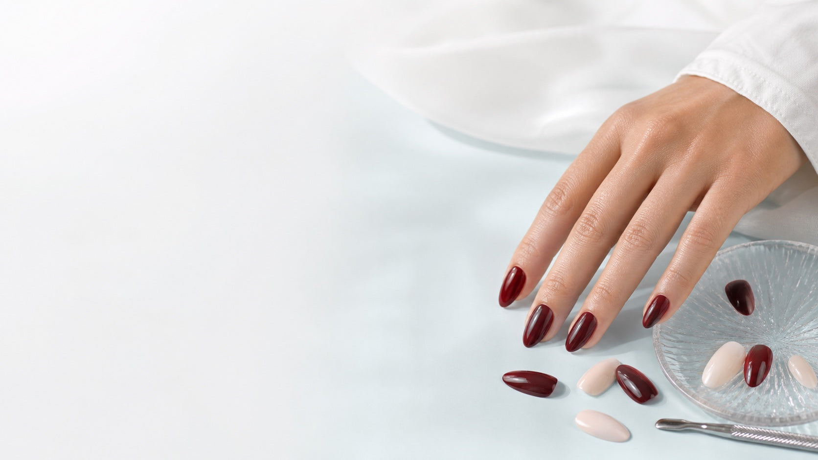 Burgundy press-on nails arranged for a Yuna manicure ritual